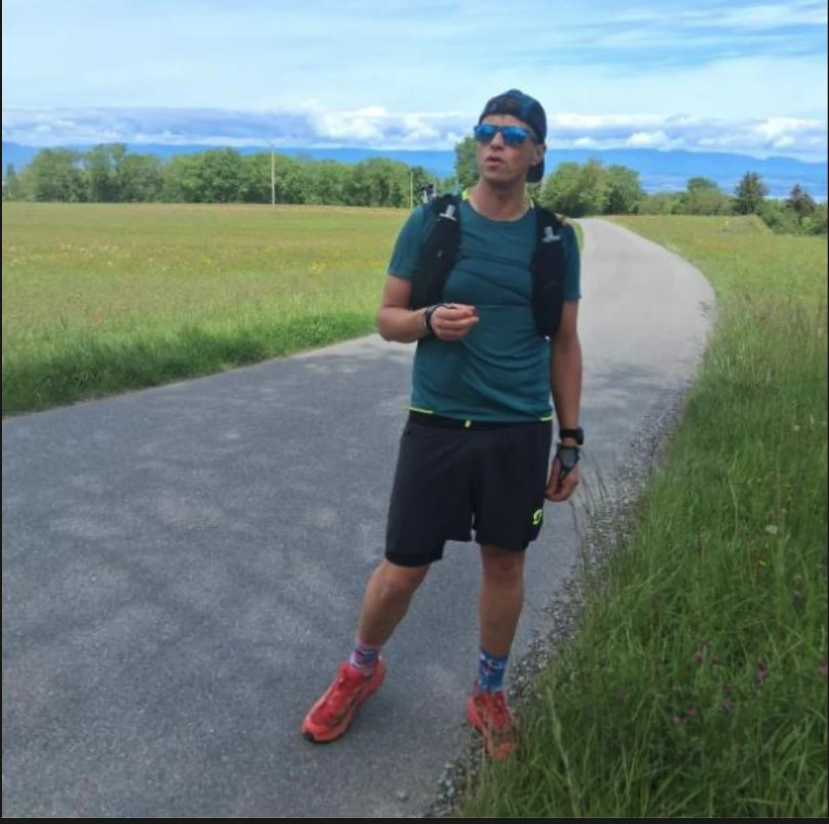 Traileur debout sur une route de campagne face aux montagnes