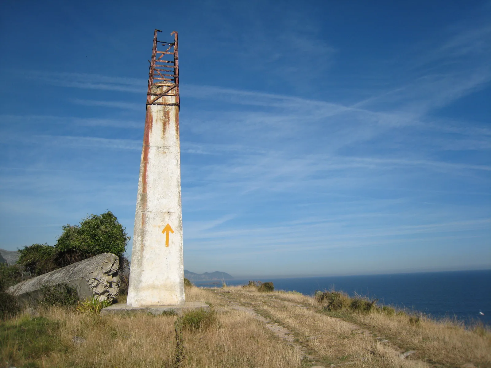 Camino del Norte arrow on a coastal marker at Islares, Cantabria.