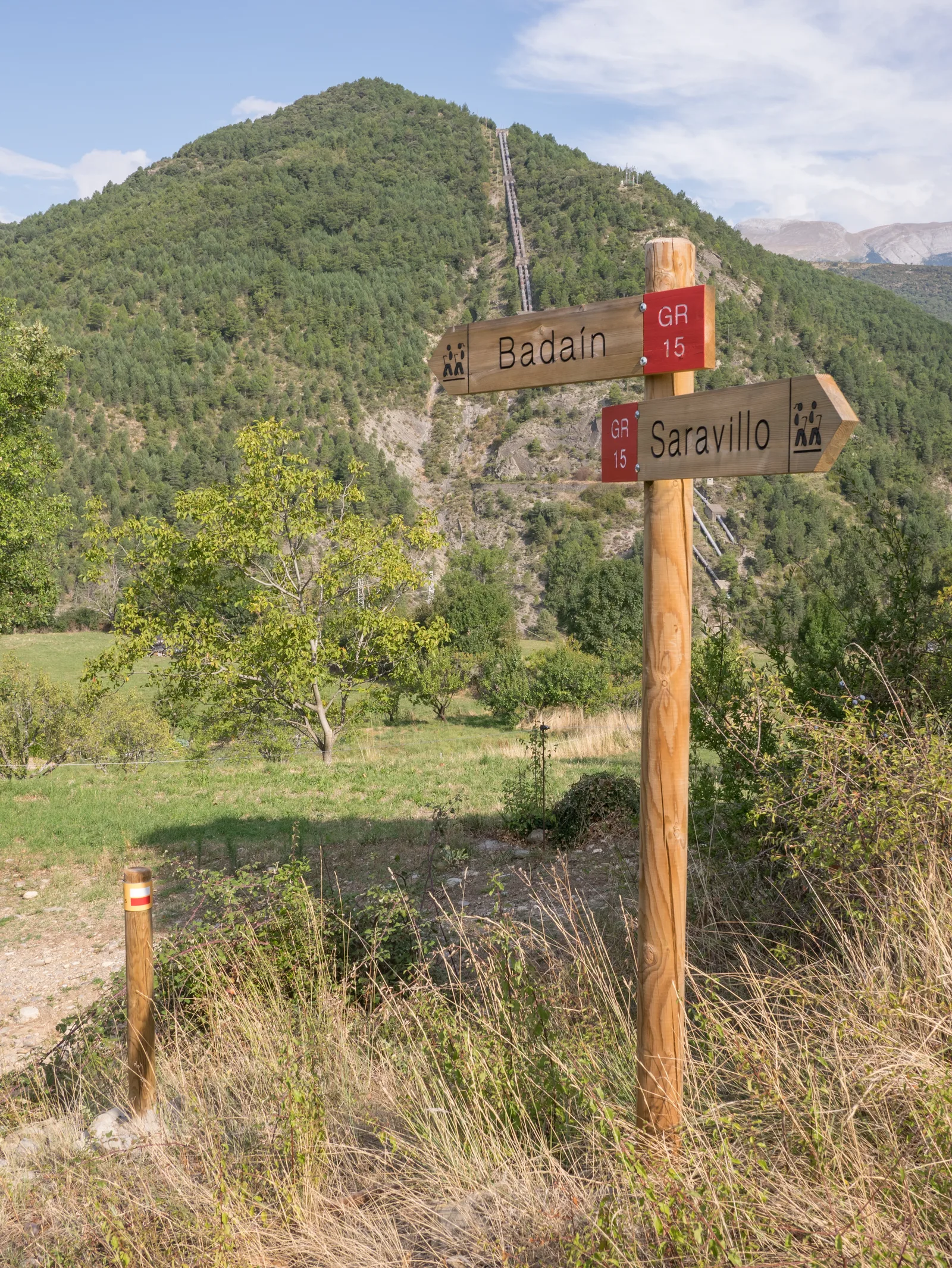 Panneau du GR 15 à Badaín devant les Pyrénées